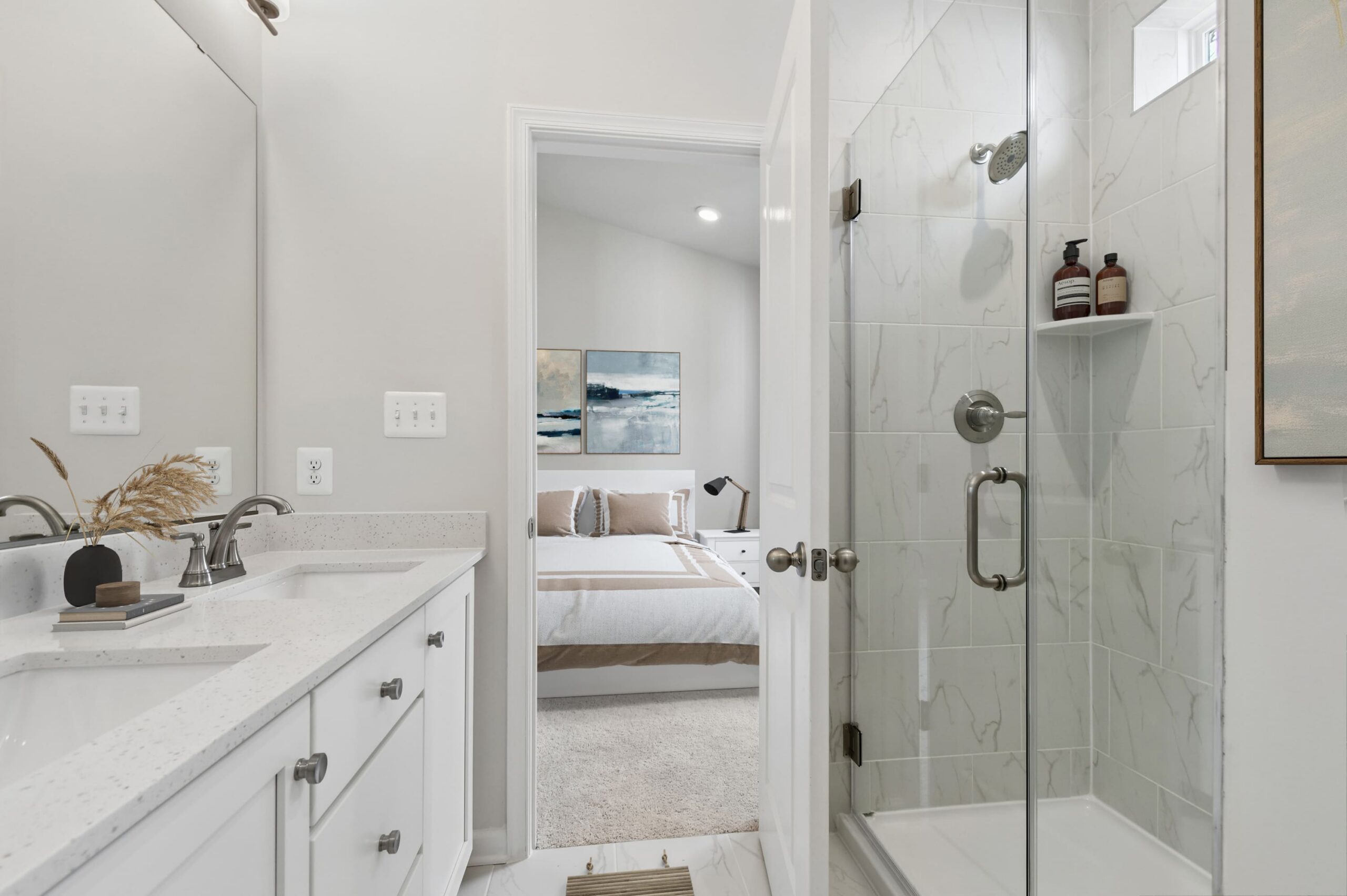 Luxury bathroom featuring white marble countertops with white cabinetry